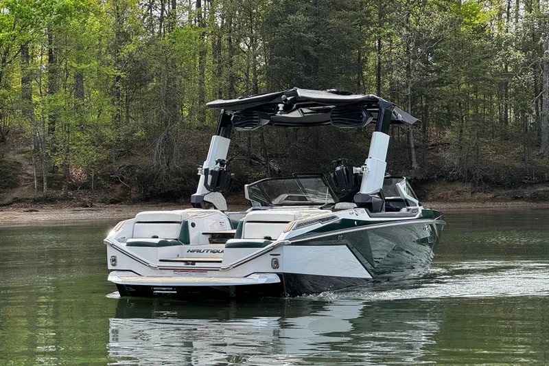 Slide: The Image of 2020 Nautique Super Air Nautique G23 Paragon on a serene lake, surrounded by lush trees. - 3