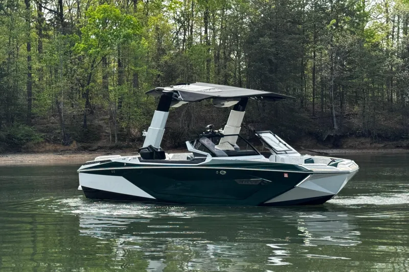 Slide: The Image of 2020 Nautique Super Air Nautique G23 Paragon boat on a serene lake with forest backdrop. - 4
