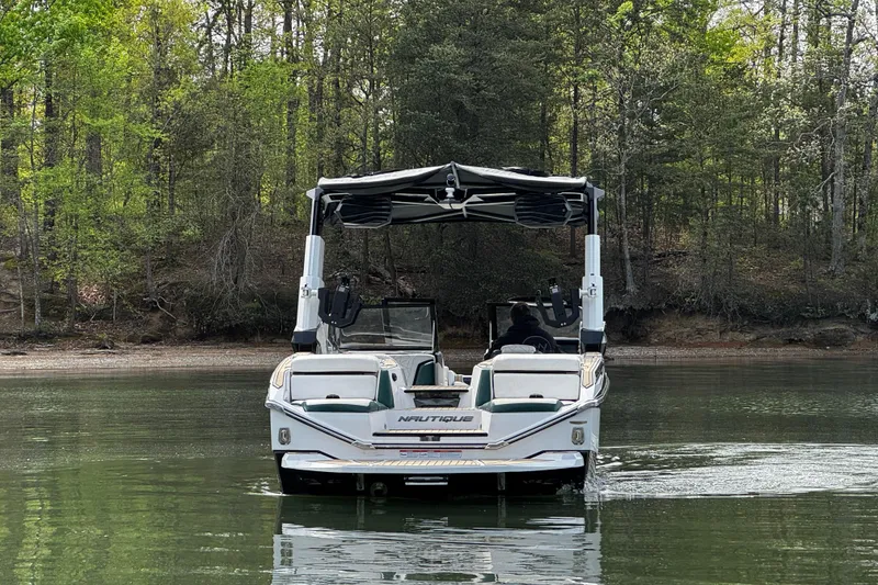 Slide: The Image of 2020 Nautique Super Air Nautique G23 Paragon on a serene lake, surrounded by lush trees. - 6