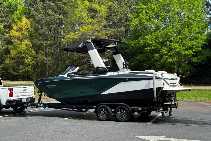 Slide: The Image of 2020 Nautique Super Air Nautique G23 Paragon boat on trailer, parked near lush green trees. - 7
