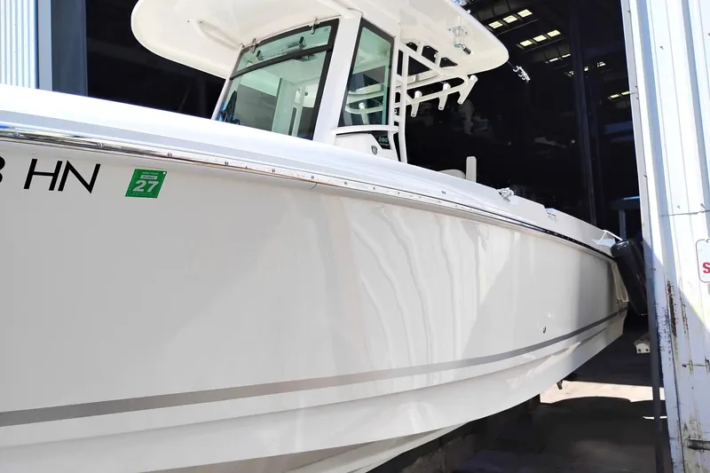 Slide: The Image of 2018 Boston Whaler 280 Outrage boat in storage, showcasing sleek design and white exterior. - 12
