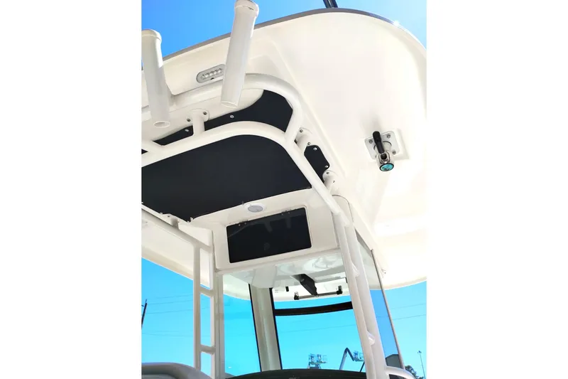 Slide: The Image of 2018 Boston Whaler 280 Outrage boat canopy and rod holders against blue sky. - 17