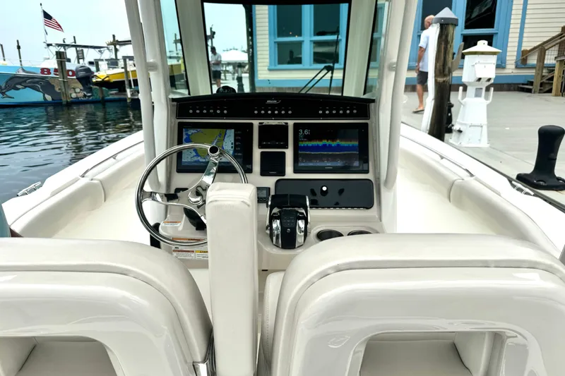 Slide: The Image of 2018 Boston Whaler 280 Outrage helm with advanced navigation displays at a marina. - 21