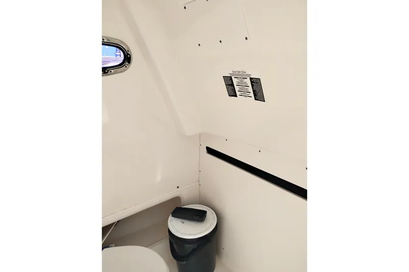 Slide: The Image of Interior of 2018 Boston Whaler 280 Outrage boat, featuring a compact restroom area. - 30
