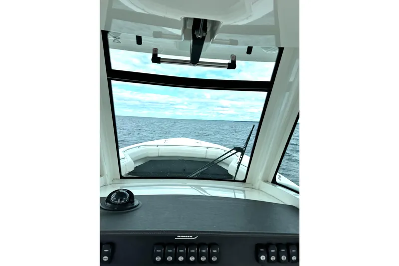 Slide: The Image of 2018 Boston Whaler 280 Outrage cockpit view, navigating open sea under cloudy sky. - 33