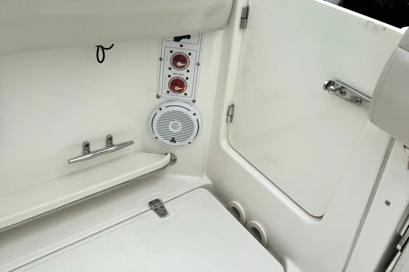 Slide: The Image of Interior view of a 2018 Boston Whaler 280 Outrage boat, featuring battery switches and speaker. - 38