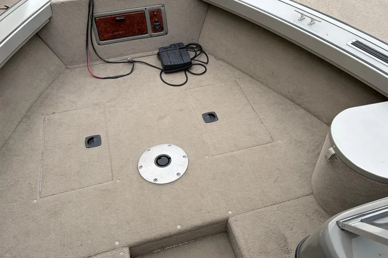 Slide: The Image of 2004 Bass Tracker Tournament V-18 boat interior with carpeted deck and storage compartments. - 11