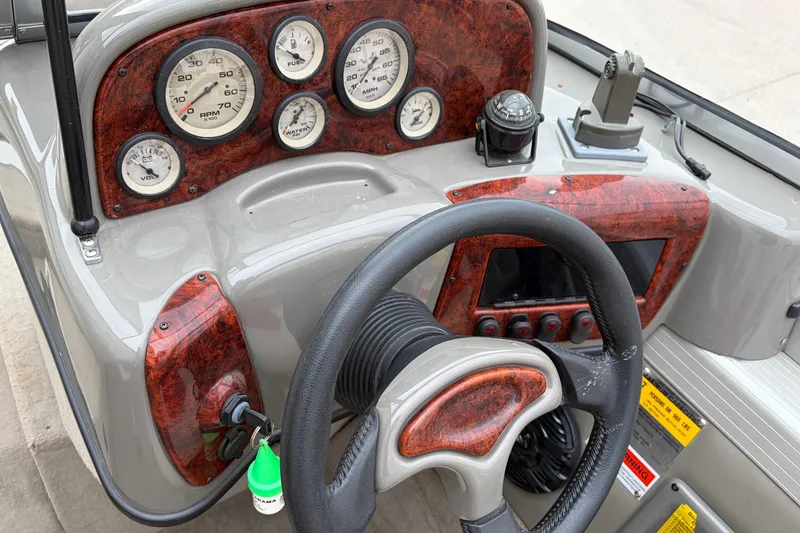 Slide: The Image of 2004 Bass Tracker Tournament V-18 dashboard with gauges and steering wheel. - 12