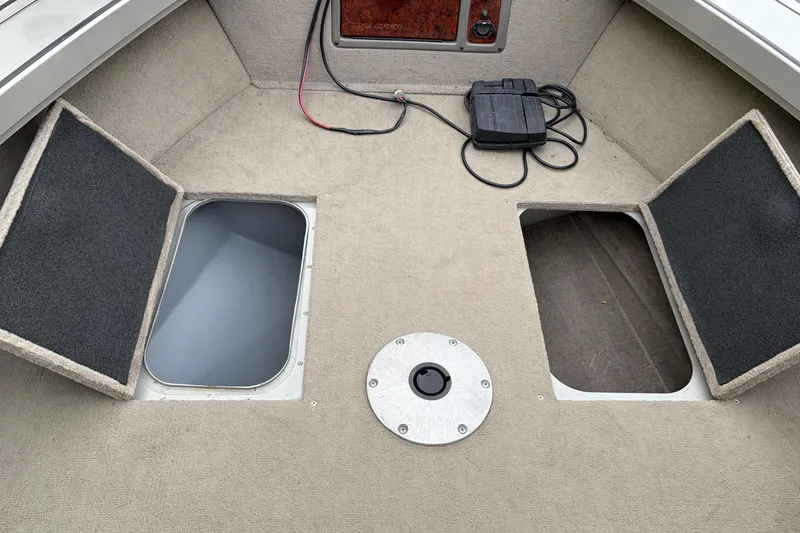 Slide: The Image of 2004 Bass Tracker Tournament V-18 boat interior with open storage compartments. - 13