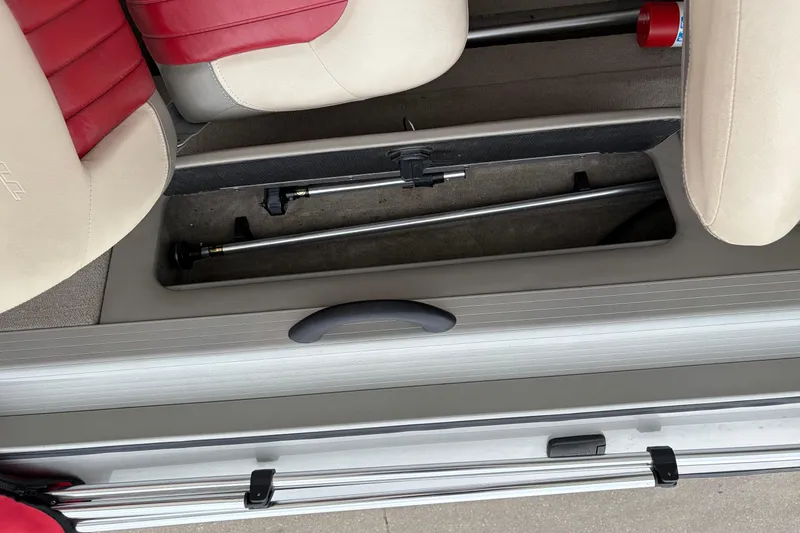 Slide: The Image of 2004 Bass Tracker Tournament V-18 boat interior storage compartment with red and beige seats. - 17