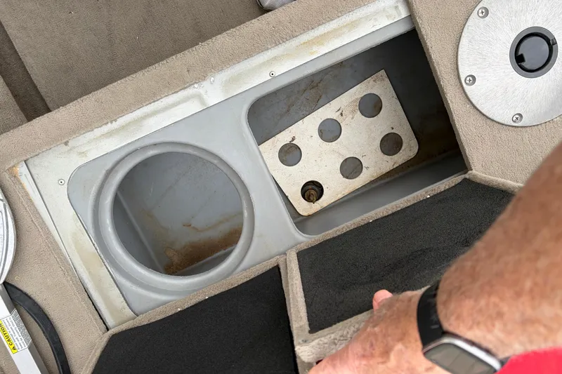 Slide: The Image of 2004 Bass Tracker Tournament V-18 storage compartment with cup holder and metal plate. - 19