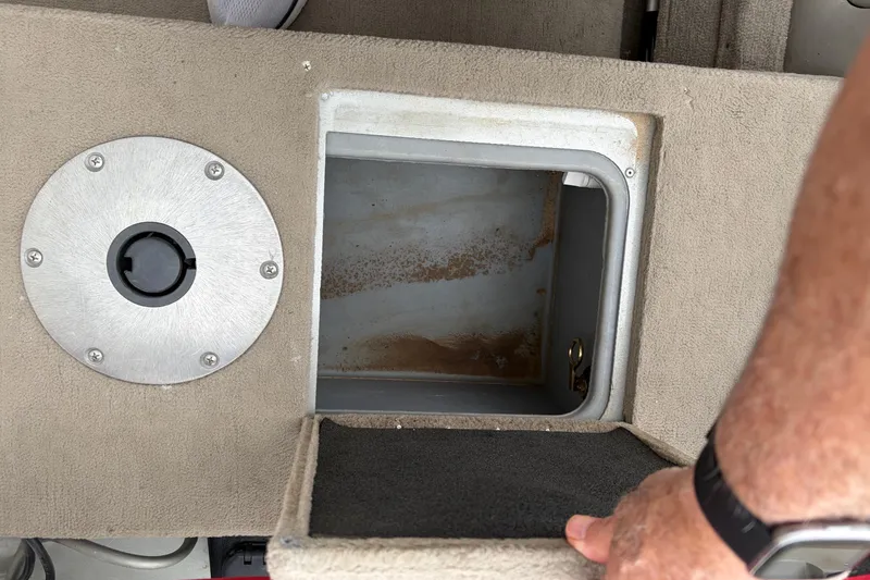 Slide: The Image of 2004 Bass Tracker Tournament V-18 storage compartment with open hatch and circular metal cover. - 20