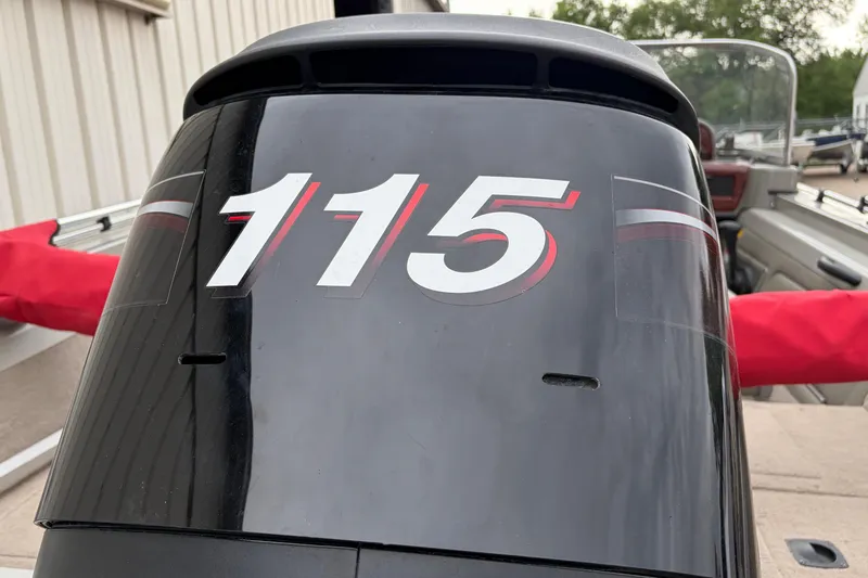 Slide: The Image of 2004 Bass Tracker Tournament V-18 boat engine with "115" decal, parked outdoors. - 26