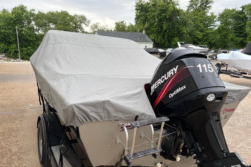 Slide: The Image of 2004 Bass Tracker Tournament V-18 boat with Mercury 115 OptiMax engine, covered and parked outdoors. - 4