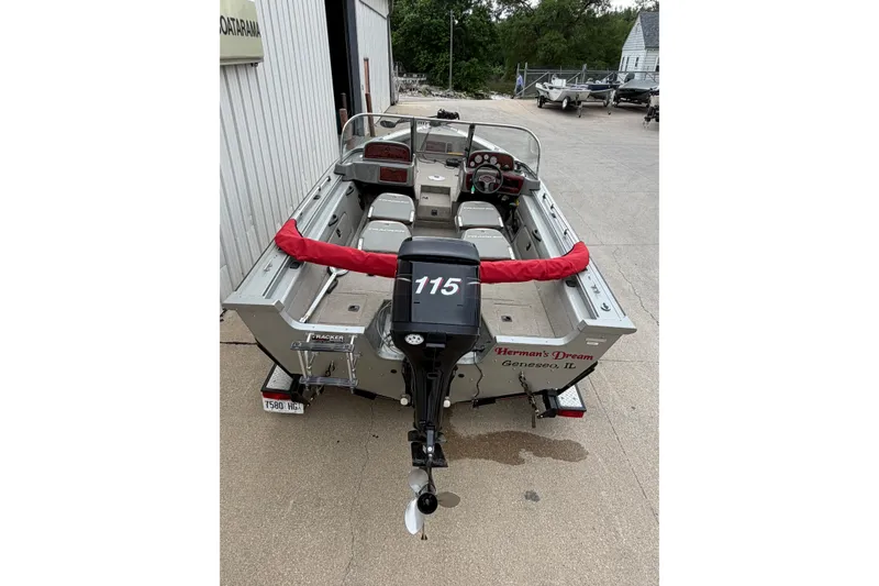 Slide: The Image of 2004 Bass Tracker Tournament V-18 boat with 115 HP motor, parked outdoors. - 5