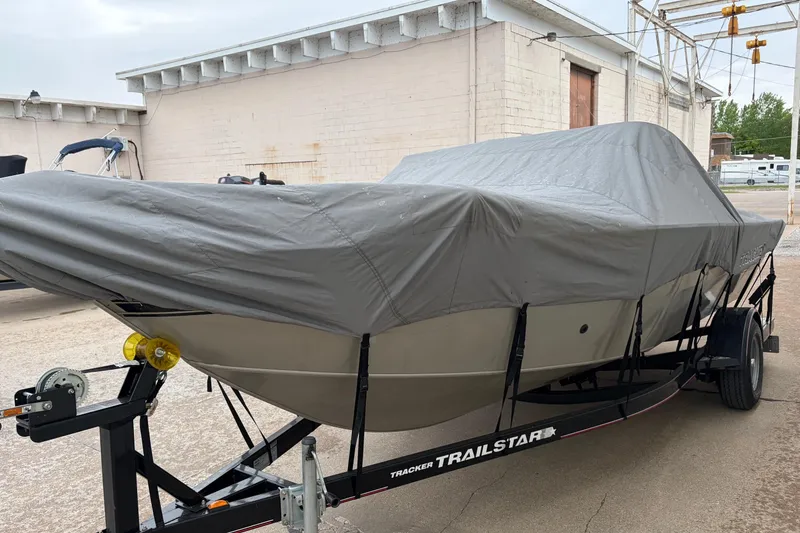 Slide: The Image of 2004 Bass Tracker Tournament V-18 boat covered on a trailer in an outdoor setting. - 7