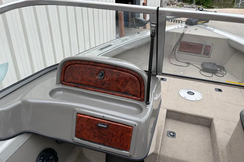 Slide: The Image of 2004 Bass Tracker Tournament V-18 boat interior with wood accents and glass windshield. - 9