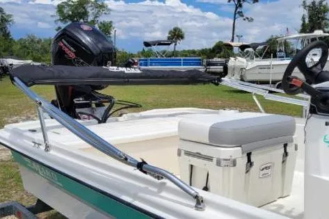Slide: The Image of 2020 Mako Pro Skiff 19 CC boat with motor and seating, parked outdoors. - 4