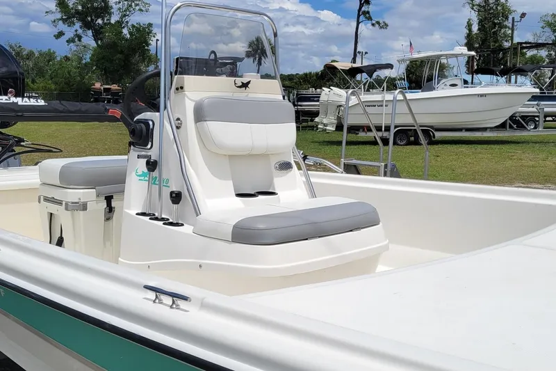 Slide: The Image of 2020 Mako Pro Skiff 19 CC boat with center console, parked on grass under a blue sky. - 5