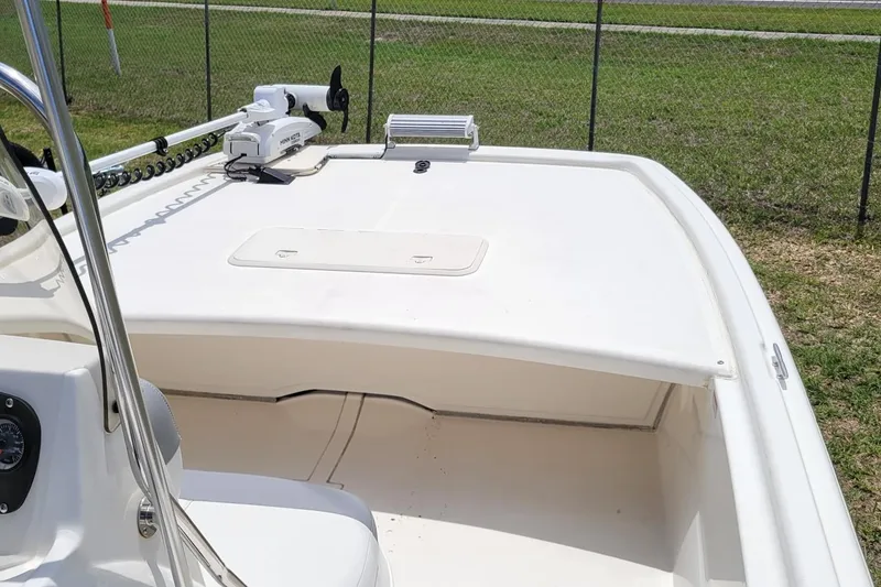 Slide: The Image of 2020 Mako Pro Skiff 19 CC boat deck with trolling motor, parked on grass. - 9
