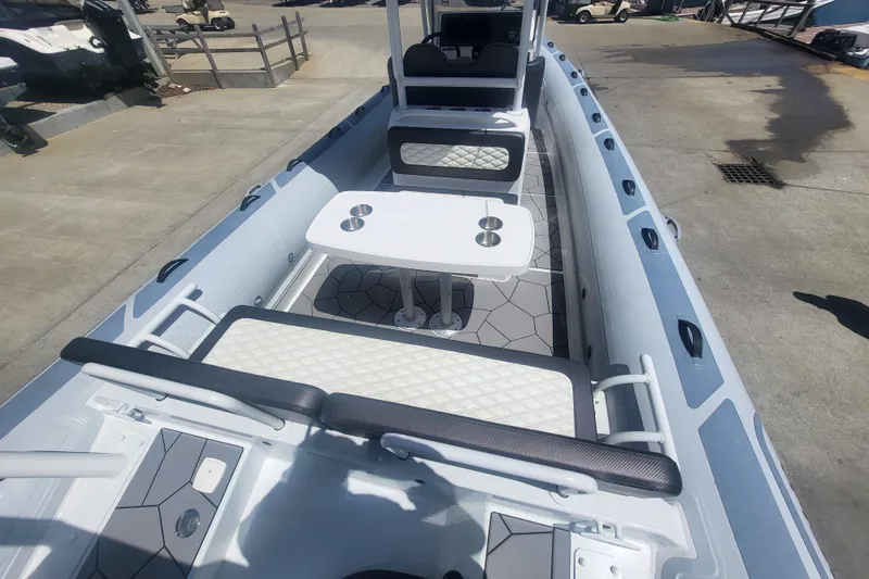 The Image of 2024 Highfield Sport 760 boat interior with seating and table, docked outdoors. - 1
