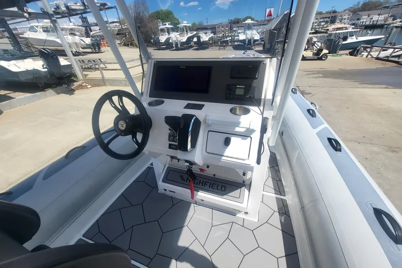 Slide: The Image of 2024 Highfield Sport 760 boat dashboard with steering wheel and navigation controls. - 3
