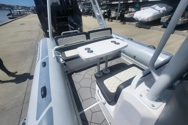Slide: The Image of 2024 Highfield Sport 760 boat interior with seating and table at a marina. - 5