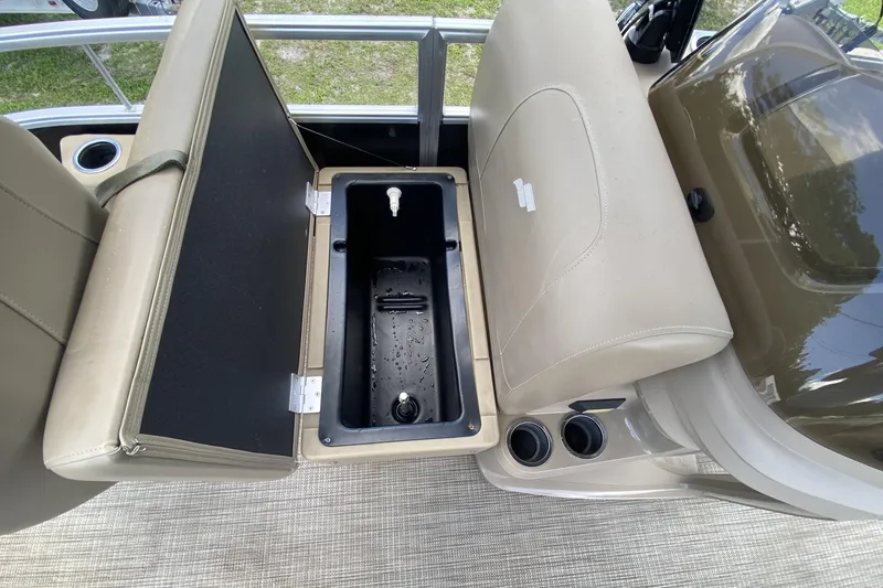 Slide: The Image of 2023 Starcraft SF 16 DLX boat interior with open storage compartment and cup holders. - 12