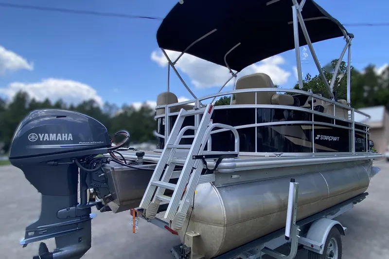 Slide: The Image of 2023 Starcraft SF 16 DLX pontoon boat with Yamaha motor on trailer. - 14