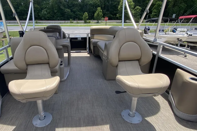 Slide: The Image of 2023 Starcraft SF 16 DLX pontoon boat interior with beige seating and carpeted floor. - 3