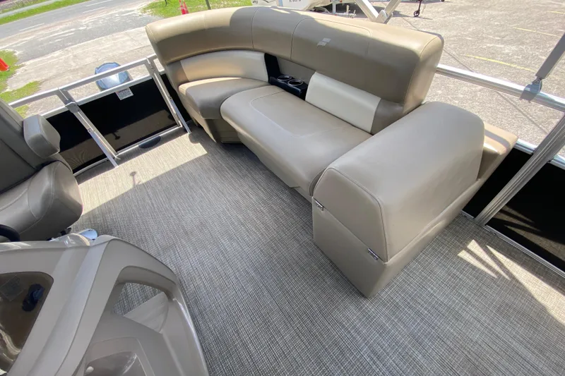 Slide: The Image of 2023 Starcraft SF 16 DLX pontoon boat interior with beige seating and carpeted flooring. - 6