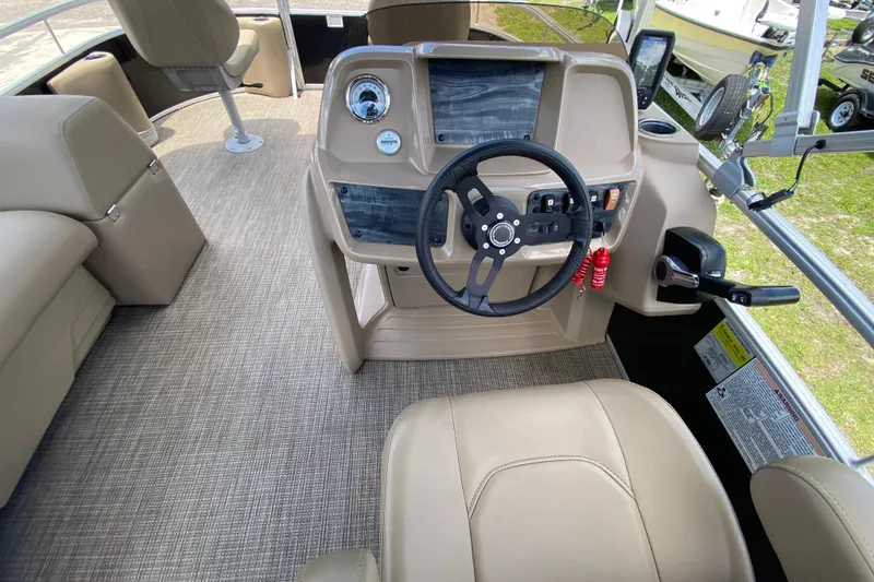 Slide: The Image of 2023 Starcraft SF 16 DLX boat interior with steering wheel and beige seating. - 8