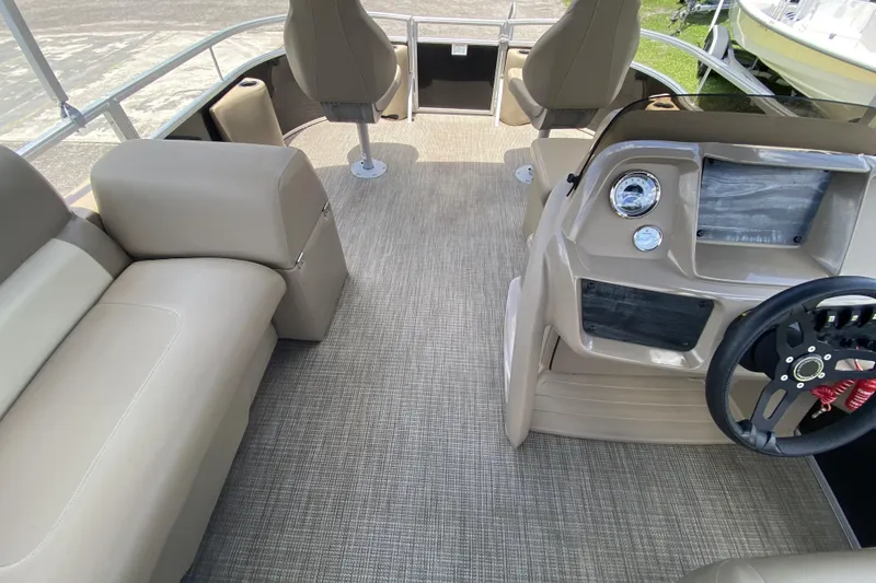 Slide: The Image of 2023 Starcraft SF 16 DLX boat interior with beige seating and modern dashboard. - 9