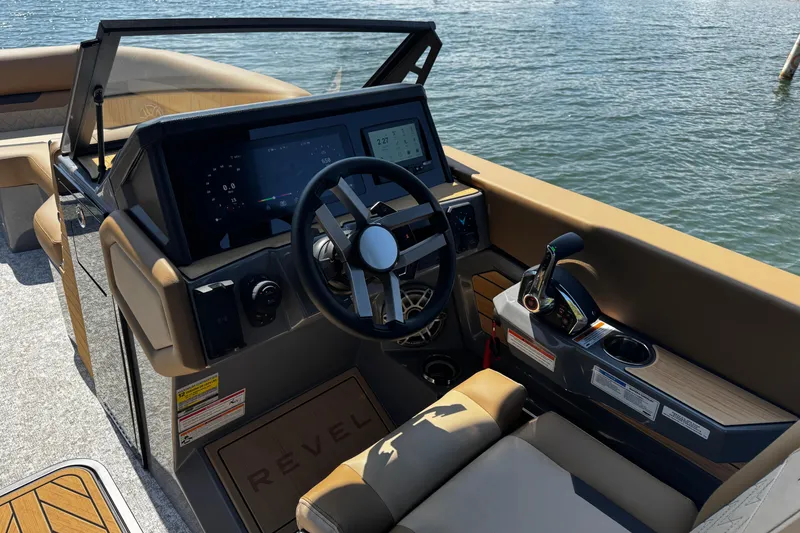 Slide: The Image of Interior view of 2026 Revel RS25L boat cockpit with modern controls and steering wheel. - 12