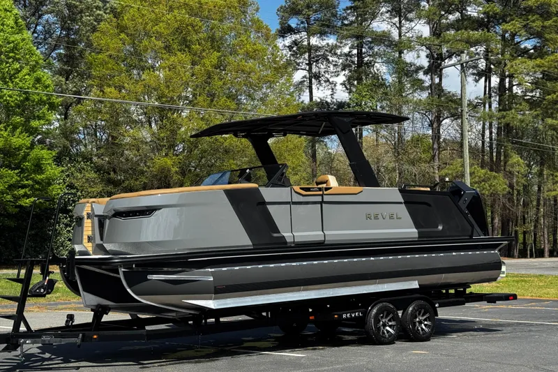 Slide: The Image of 2026 Revel RS25L luxury pontoon boat on trailer, surrounded by trees. - 17