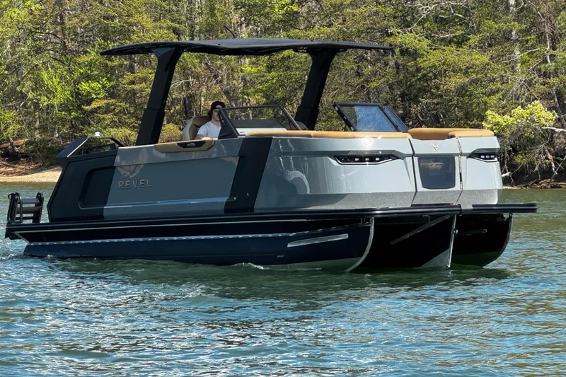 Slide: The Image of 2026 Revel RS25L pontoon boat cruising on a scenic lake. - 2