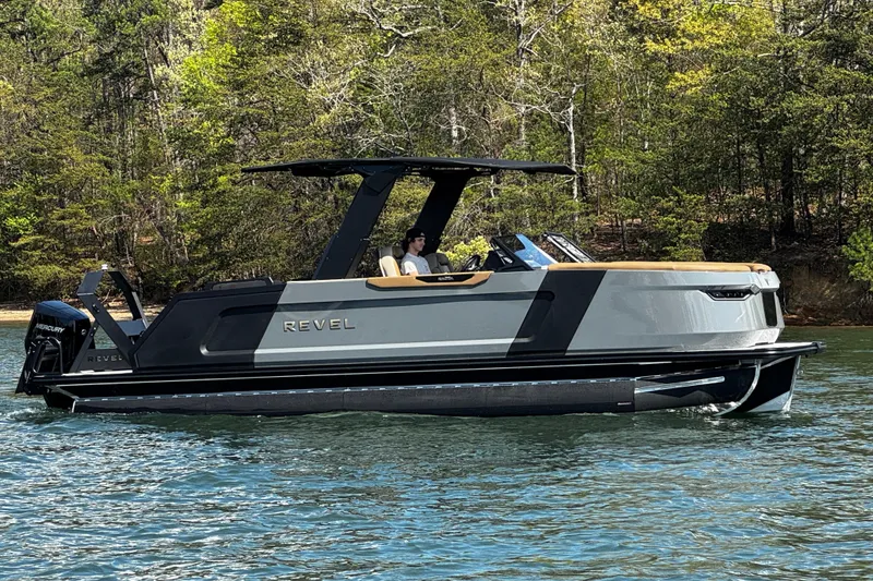 Slide: The Image of 2026 Revel RS25L boat cruising on a serene lake with lush forest backdrop. - 3
