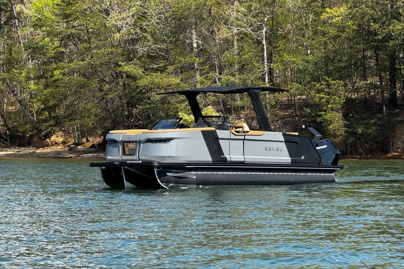 Slide: The Image of 2026 Revel RS25L pontoon boat on a serene lake, surrounded by lush trees. - 6