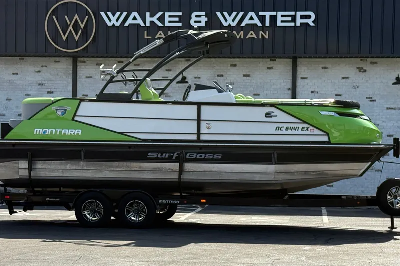 The Image of 2021 Montara 25 Surf Boss boat in green and white, parked at Wake & Water dealership. - 0