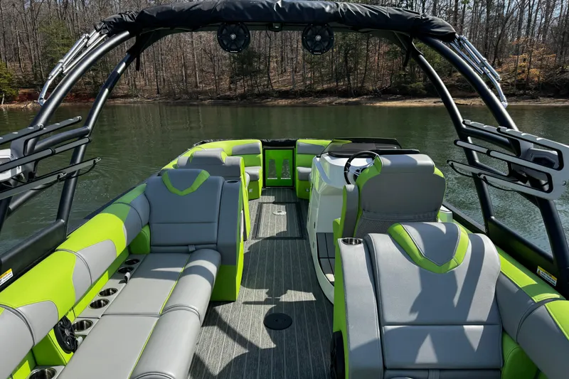 Slide: The Image of 2021 Montara 25 boat interior with green and gray seating on a calm lake. - 12