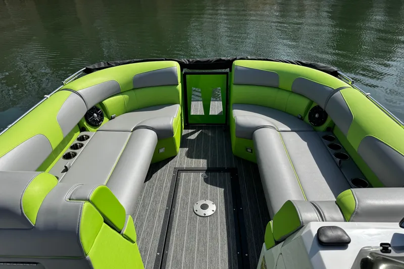 Slide: The Image of Luxurious 2021 Montara 25 boat interior with green and gray seating, cup holders, and speakers. - 14