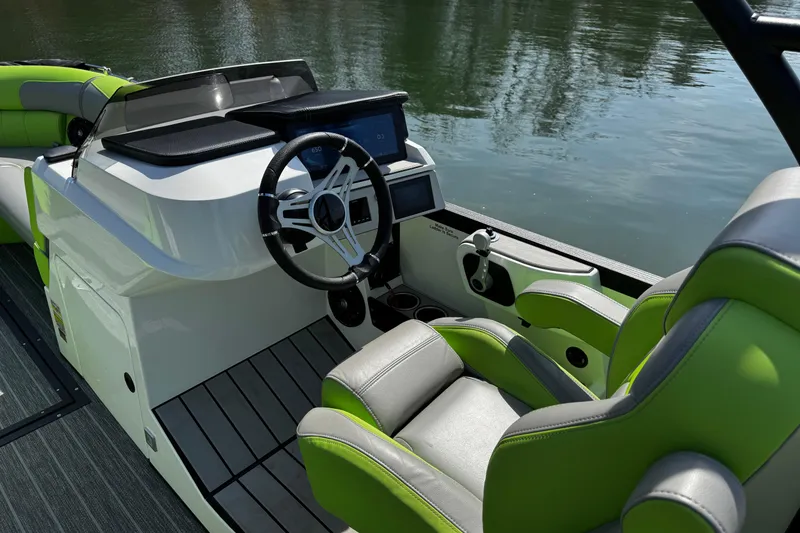 Slide: The Image of Interior of 2021 Montara 25 boat with modern steering and green-accented seating. - 16