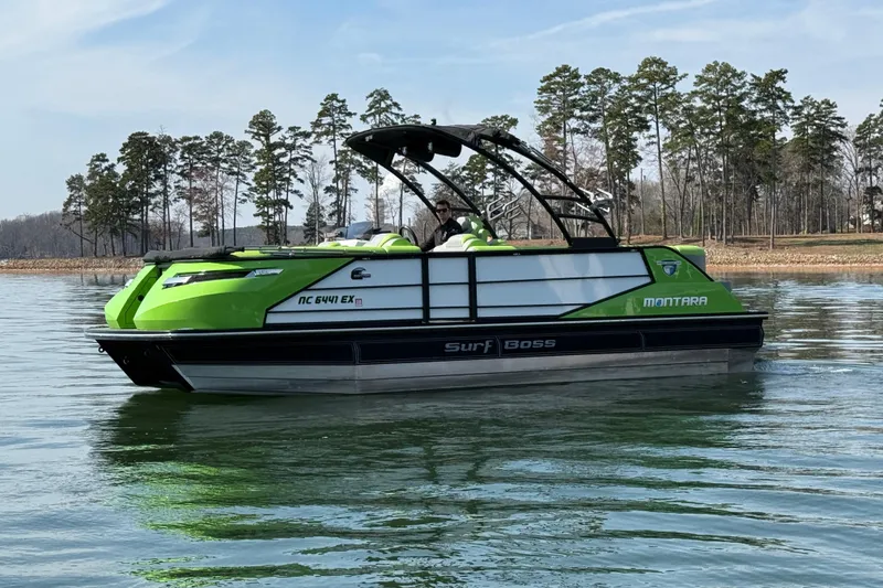 Slide: The Image of 2021 Montara 25 boat on a calm lake, surrounded by trees. - 6