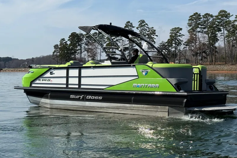 Slide: The Image of 2021 Montara 25 Surf Boss boat on a lake, featuring vibrant green accents. - 7