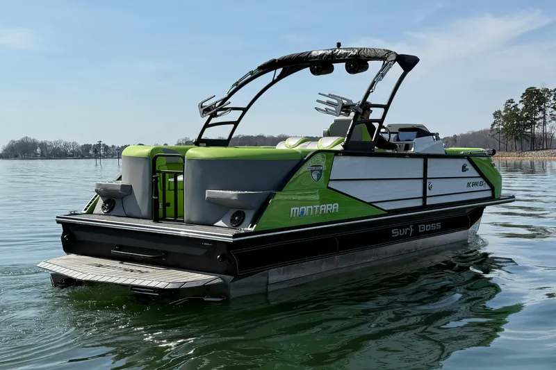 Slide: The Image of 2021 Montara 25 boat on calm water, featuring sleek design and vibrant green accents. - 8