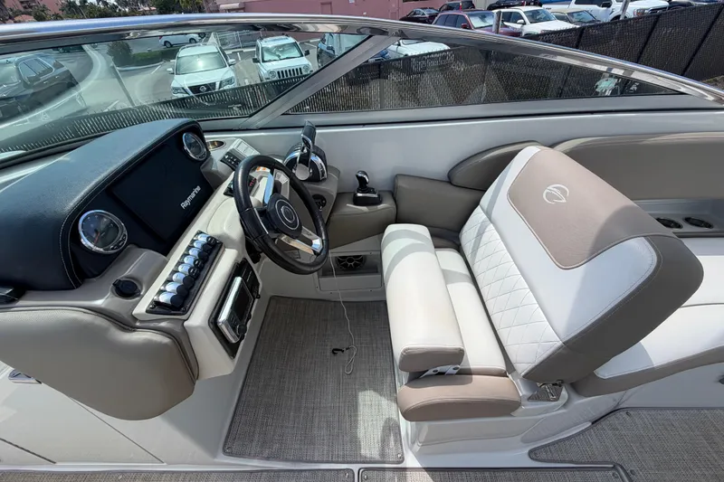 Slide: The Image of 2019 Crownline Eclipse E295 XS boat interior with steering wheel and plush seating. - 13