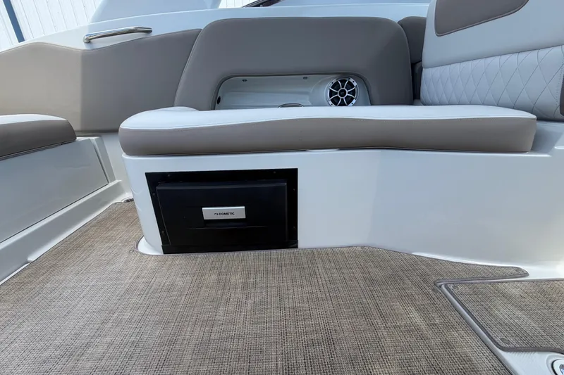 Slide: The Image of 2019 Crownline Eclipse E295 XS boat interior with cushioned seating and built-in Dometic cooler. - 18