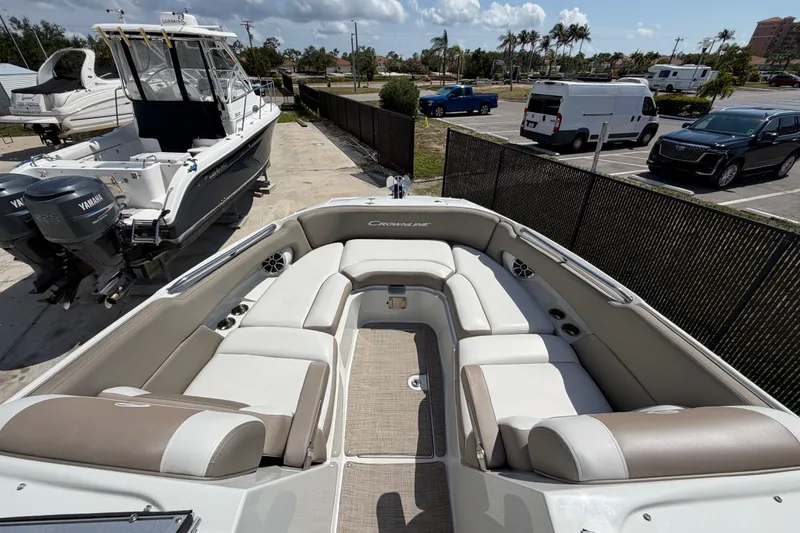 Slide: The Image of 2019 Crownline Eclipse E295 XS boat with spacious seating and modern design in a marina setting. - 27
