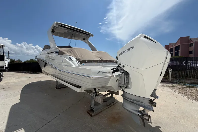 Slide: The Image of 2019 Crownline Eclipse E295 XS boat with Mercury engine, docked under a clear blue sky. - 3