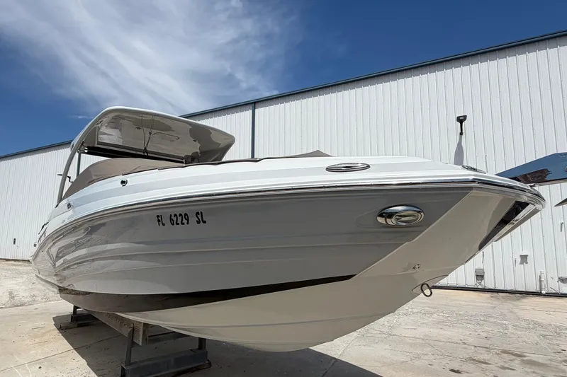 Slide: The Image of 2019 Crownline Eclipse E295 XS boat docked outdoors under a clear blue sky. - 4